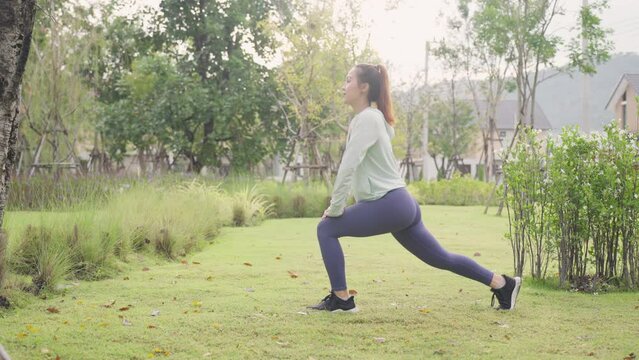 Asian woman stretching her body warm up before workout outside. New normal workout. Girl in sportswear exercises outside at morning sunrise for health and wellbeing. slow motion b roll.