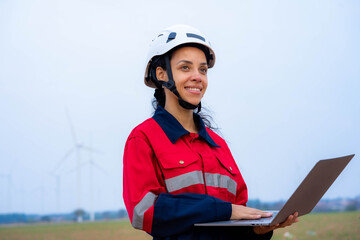 Female engineer or architect stands outdoors with laptop to work outside.