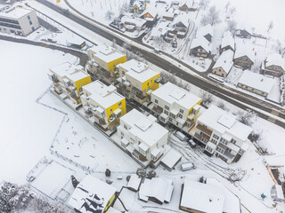 New apartment buildings in winter. Covered in snow. Drone aerial view