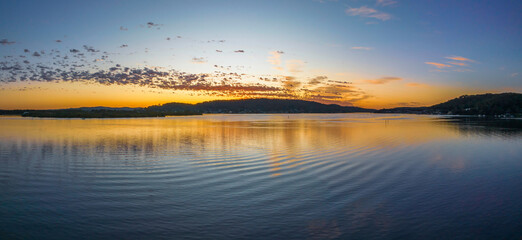 Pretty sunrise waterscape panorama with low colourful clouds - obrazy, fototapety, plakaty