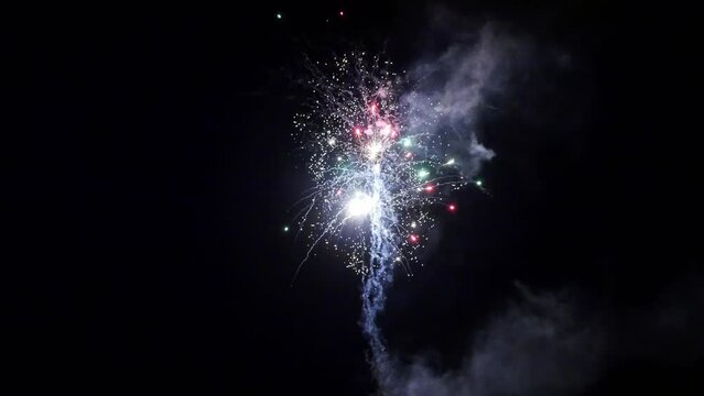Explosion of bright colorful part of fireworks on black background to create a set salute on video for holiday new year, birthday, wedding or other celebration.