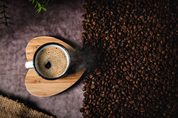 Coffee in cup on wooden base in heart with coffee beans and flax, roasted coffee