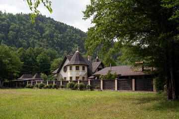 View of a cottage in the village of Guzeripl against the backdrop of the Caucasus Mountains on a...