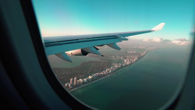Airplane Landing in Miami USA. Beautiful aerial view of Miami landscape from window of landing aircraft. Viewing airport from the passenger cabin window. Airplane Window Seat - View of Wing of Plane. 