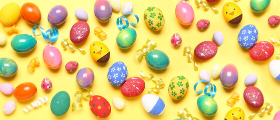Many colorful Easter eggs on yellow background