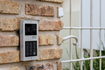 Modern intercom on brick wall outdoors, closeup