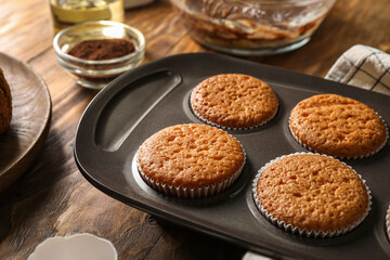 Tray with tasty muffins on wooden table, closeup