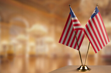 Small flags of the Liberia on an abstract blurry background