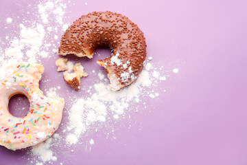 Tasty bitten donuts and sugar powder on color background