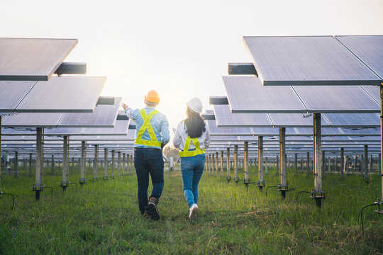 Male and female employee maintenance panels collect solar energy. Engineer working on checking and maintenance equipment at industry solar power.