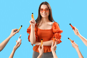 Young woman and hands with disposable electronic cigarettes on blue background