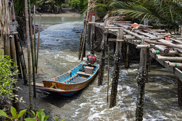 Fototapeta na wymiar An wooden boat with the engine is moored in the water canal, Thailand