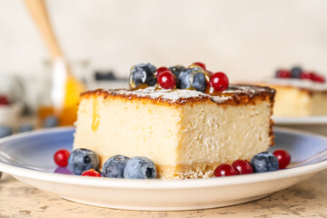 Plate with piece of cottage cheese casserole and berries on light background, closeup