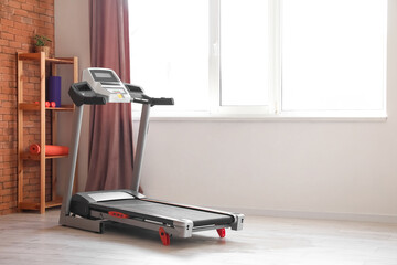 Interior of room with modern treadmill near window