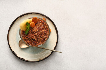 Plate with glass of delicious chocolate pudding, almond and mint on white table