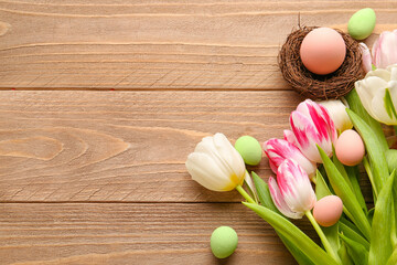 Fototapeta na wymiar Beautiful tulip flowers and nest with Easter eggs on wooden background