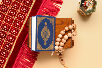 Rehal with Koran, prayer beads, mat and Muslim lantern for Ramadan on color background