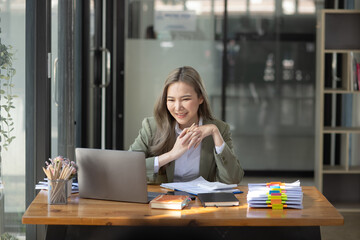 Happy excited young successful business woman and working online at the table in office, Asian business woman.