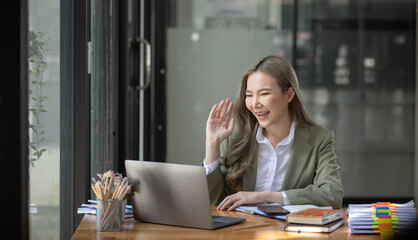 Happy excited young successful business woman and working online at the table in office, Asian business woman.