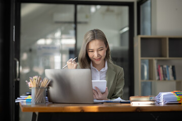 Fototapeta premium Cheerful asian businesswoman working at table office. 