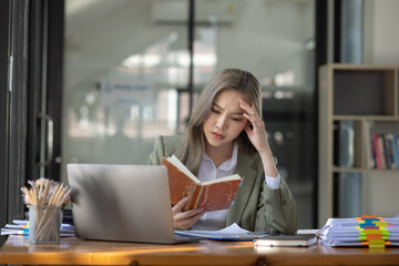 Obraz premium Asian businesswoman are stressed and tired from work sitting at desk in the office, feeling sick at work, stress from work. 