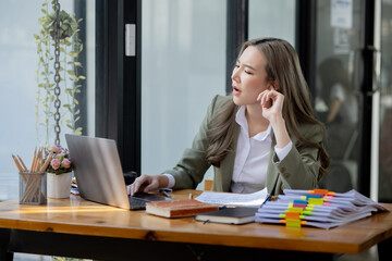 Asian businesswoman are stressed and tired from work sitting at desk in the office, feeling sick at work, stress from work. 