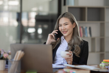 Cheerful asian businesswoman working at table office. 