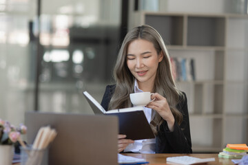 Obraz premium Cheerful asian businesswoman working at table office. 