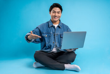 Full body young  Asian using laptop on blue background