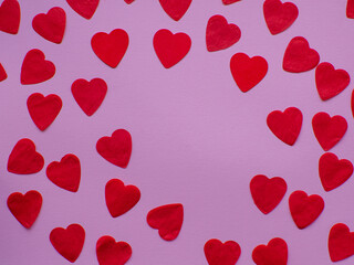 Red heart paper on pastel pink background, top view with copy space. Greeting card. Valentines day holiday concept. Flat lay with a lot of tiny heart-shaped papers with space for text. February 14th. 