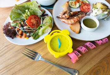 Yellow alarm clock with IF (Intermittent Fasting) 16 and 8 diet rule and weight loss concept.-Diet plan concept
