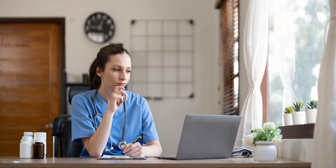 Beautiful female doctor sitting at office desk working. Health care and prevention concept