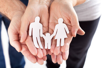 Familie beschützen, Papierfamilie in den Händen halten