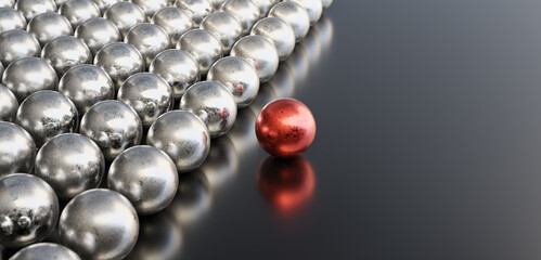 Leadership concept, red leader ball, standing out from the crowd of silver balls, on black background with empty copy space on right side. 3D Rendering