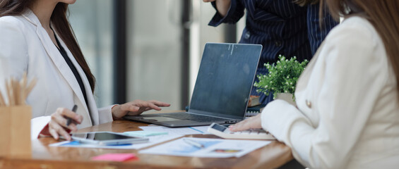Technology and financial advisory services concert. Business teamwork and working on digital laptop computer with advisor showing plan of investment to clients at table office. Digital marketing.