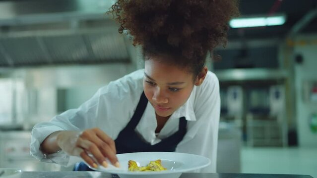 Beautiful female chef looking to camera with smile at modern kitchen. She enjoying with cooking food at restaurant kitchen. Chef, Lifestyle, Happiness, Success, Education and Business concept.