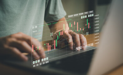 Selective focus at keyboard of laptop while business person while typing on smartphone to execute buy or sell order while trade for stock exchange or crypto currency exchange or investment in business