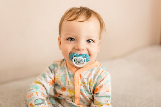 Portrait of infant boy smiling with dummy