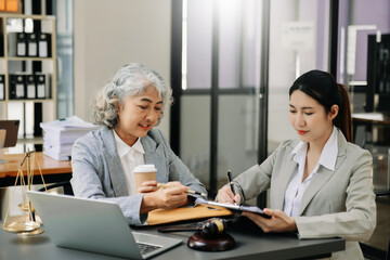 Fototapeta premium Asian business team and lawyers discussing contract papers sitting at the table. Concepts of law, advice, legal services.