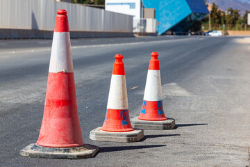 Traffic cones stand in a row on an asphalt road. Devices for temporary marking of roads. Avriynye...