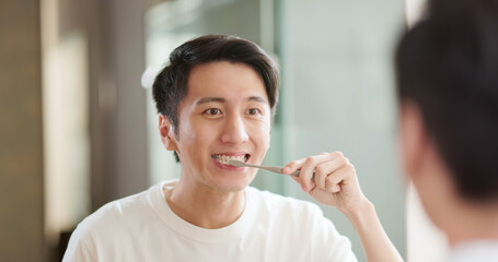 Asian man brushing teeth