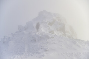 Fototapeta na wymiar Climbing tourists in winter to the peak of a mountain peak
