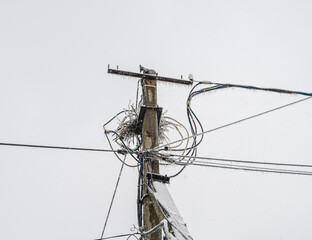 Electric pole covered with snow and ice in winter.