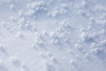 Close-up macro photo of graupel snow, also called soft hail, hominy snow, or snow pellet.
