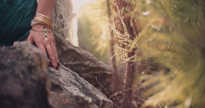 Cropped shot of a woman's hand with boho style jewelry in a natural setting, Panning in Slow Motion