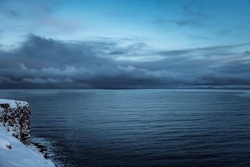 Abwaschbare Fototapete Iceland cloudy stormy blue sky over the ocean with coastline after sunset © Simon Schmitt