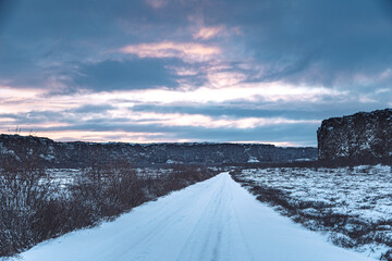 Iceland snow road to Ásbyrgi Canyon with sunset over landscape