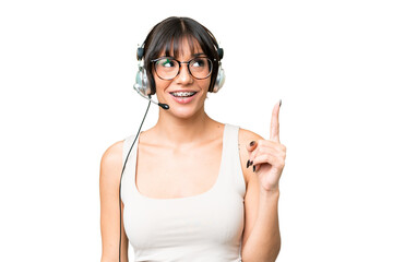 Naklejka premium Telemarketer caucasian woman working with a headset over isolated background pointing up and surprised