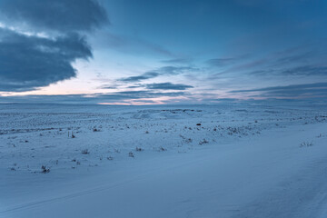 Iceland sunrise or sunset winter panorama snow landscape with clouds and blue yellow sky