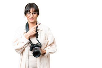 Young photographer caucasian woman over isolated chroma key background pointing to the side to present a product